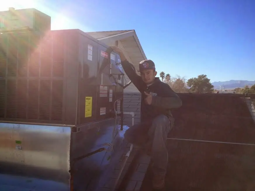HVAC technician performing Boiler Repair on a rooftop unit in La Porte
